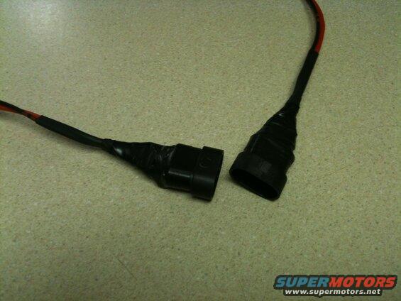 Two black electrical connectors with wires taped together.