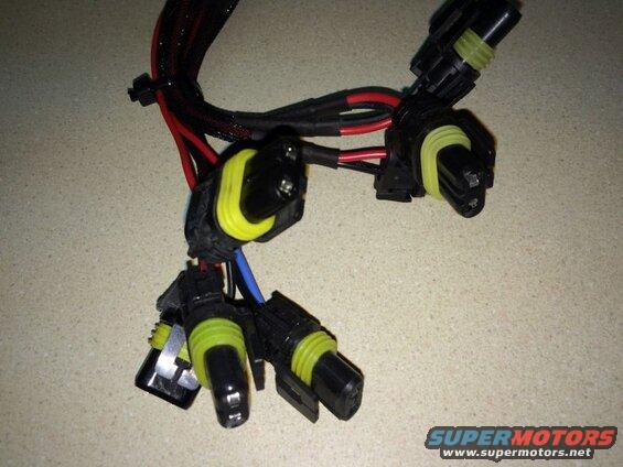 Wiring harness with black connectors and yellow seals, red and black wires.