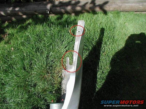 The top hole is the "hidden" 10mm bolt. The lower "U" shaped part slides into a tab on the fender.