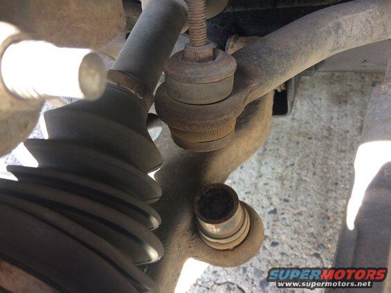 Close-up of vehicle suspension with tie rod end and CV boot.