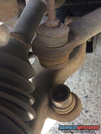 Close-up of rusted car suspension parts, including ball joint and tie rod end.