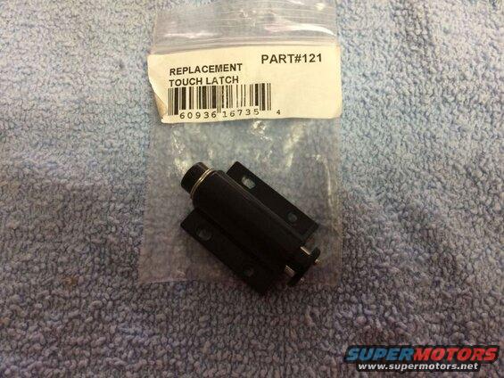 Black replacement touch latch in packaging on a blue textured surface.