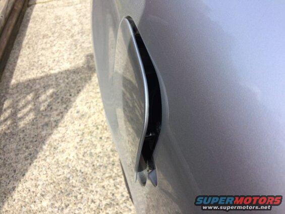 Close-up of an open fuel door on a silver car.