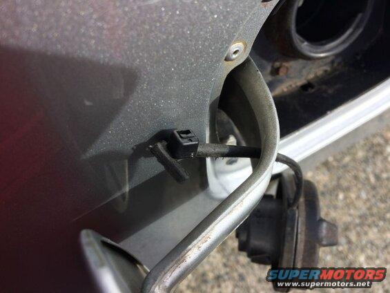 Broken fuel door tether on a gray car