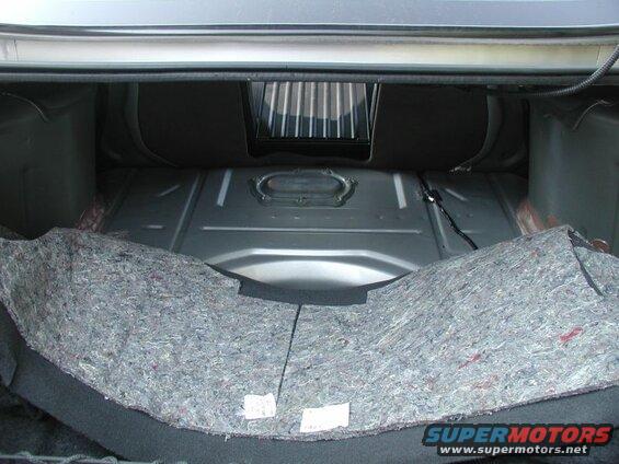 Pull back the carpet in the trunk to expose the access panel.
