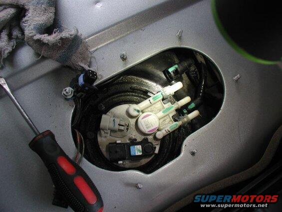 Disconnect the three fuel lines. For the two outer hoses, squeeze the two tabs inward and pull the hose off. For the inner hose, squeeze the end inward and pull the hose off.