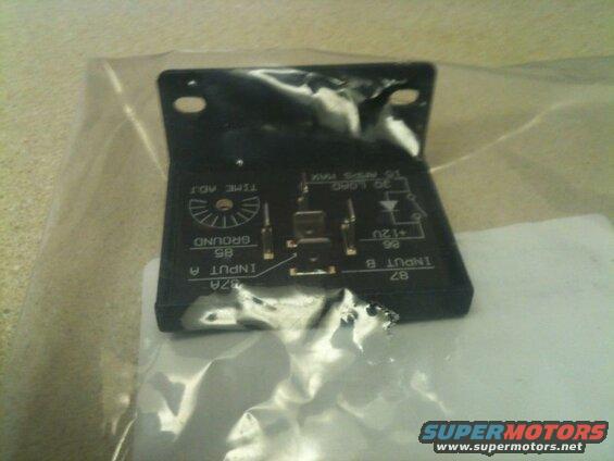 Black automotive relay with text labels in a plastic bag.