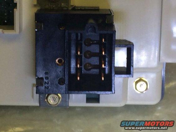 Black electrical connector with copper pins on white housing