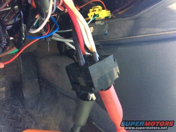 Vehicle wiring harness and connectors under dashboard with brake pedal.