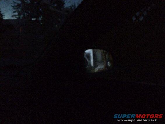 Looking out the right window from the drivers seat, into the sideview mirror; reverse lights on.