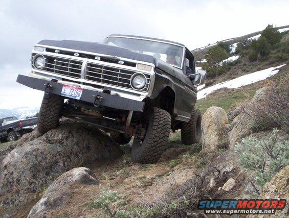 Black Ford truck with lifted suspension climbing rocks, license plate E 72188