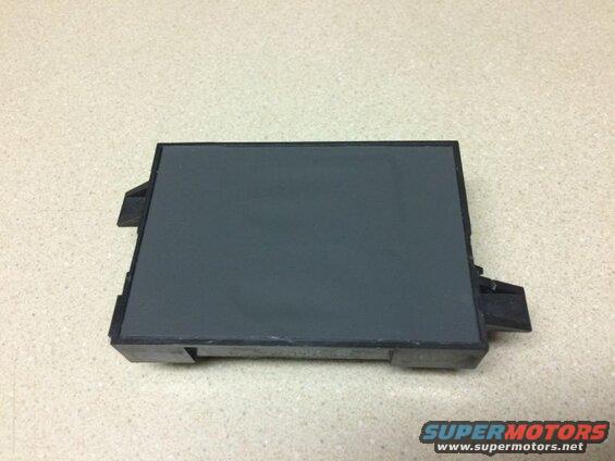 Dark gray electronic module with black plastic tabs on speckled surface
