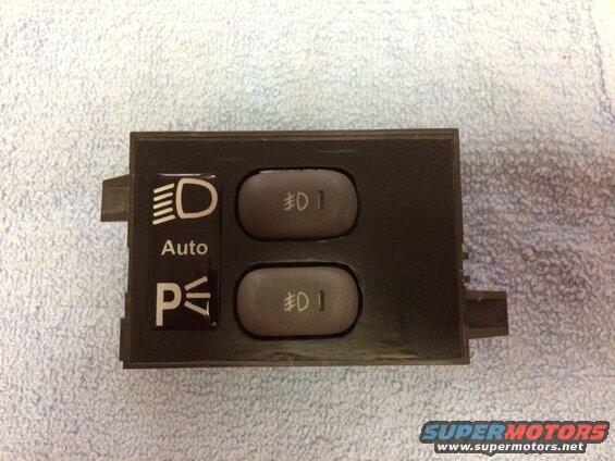 Automotive headlight control switch with icons for headlights, Auto, and parking lights.