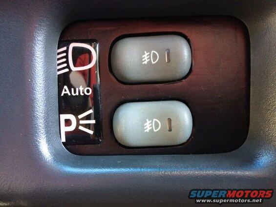 Car dashboard with headlight controls including Auto and P symbols, and two fog light buttons.