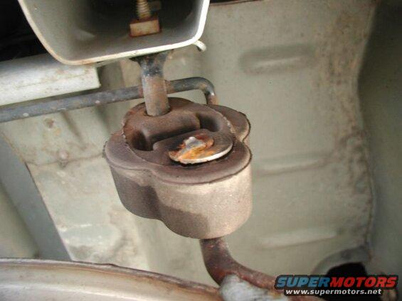 Rusted exhaust hanger bracket on a vehicle undercarriage