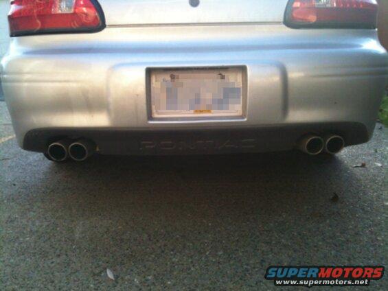 Rear view of a silver 2002 Pontiac Grand Prix with dual exhaust tips.