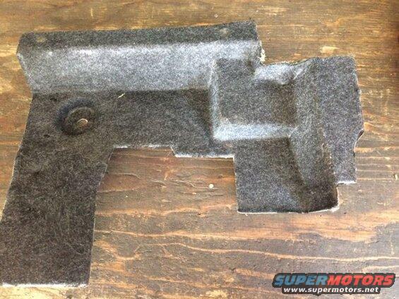 Gray felt automotive part with molded shape and fastener on wood