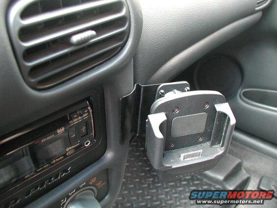 Close-up of a car's dashboard showing a phone mount next to the air vent and stereo.