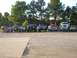 1989 Ford Bronco - A collection of trucks and SUVs are lined up outdoors with people standing near them.