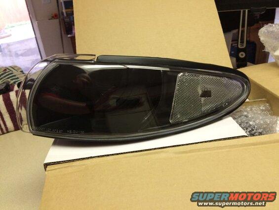 Black aftermarket headlight assembly with text SAE DOT 12P AP2 87 KS-GM138