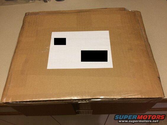 Cardboard box with a white label and blacked-out information.