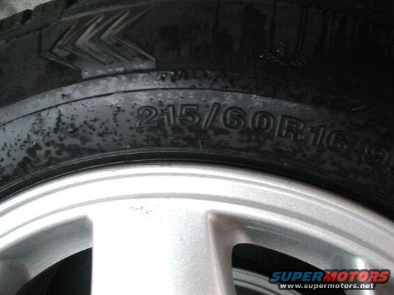 Close-up of a tire with size 215/60R16 99 on a silver alloy wheel.