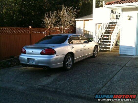 Silver 2002 Pontiac Grand Prix parked on concrete driveway.