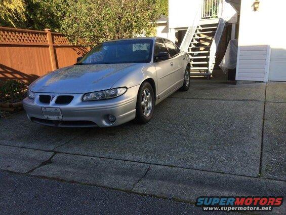 Silver 2002 Pontiac Grand Prix sedan parked in a driveway.
