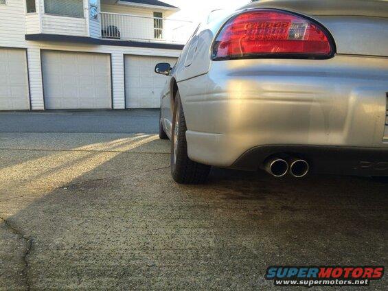 Rear driver's side of a silver 2002 Pontiac Grand Prix with dual exhaust.
