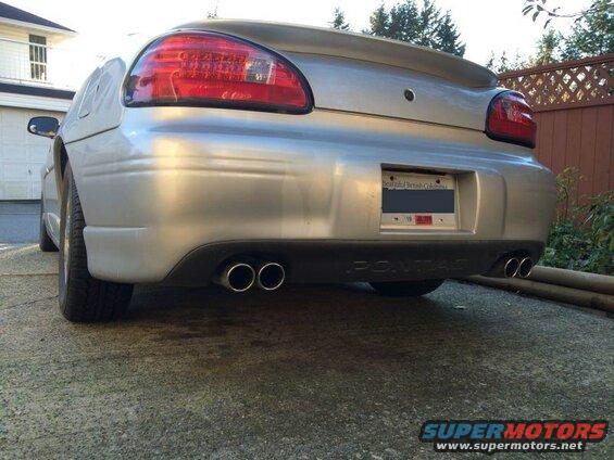 Rear driver's side of a silver 2002 Pontiac Grand Prix with dual exhaust pipes.