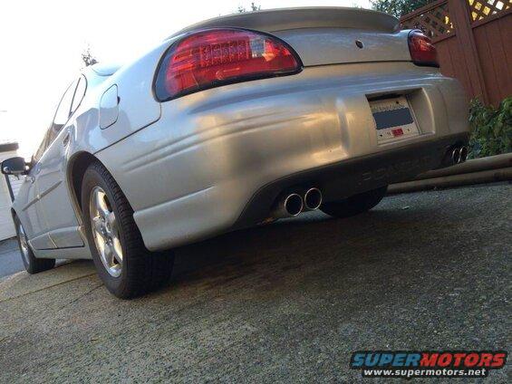 Silver sedan rear passenger side view, showing dual exhaust and Pontiac text.