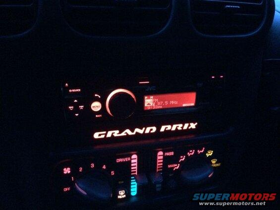 Interior dashboard of a 2002 Pontiac Grand Prix at night, showing the JVC radio and climate controls.