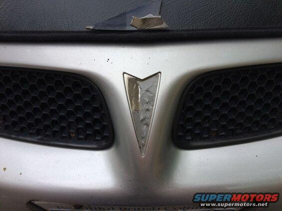 Use a small flathead screwdriver and gently pry up the old emblem.