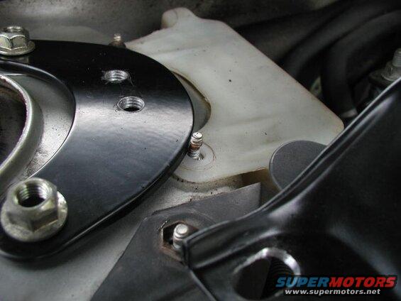 On the passenger side, remove the nut for the coolant tank.