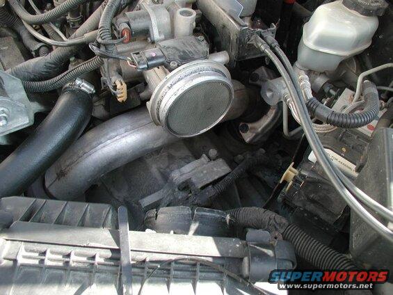Undo the clamp at the airbox and remove the air intake hose.