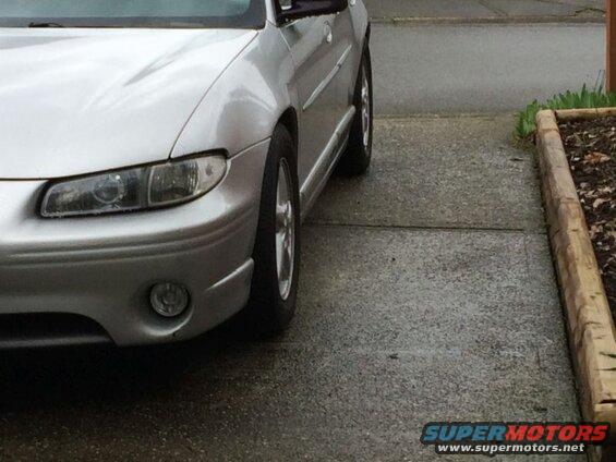 Silver 2002 Pontiac Grand Prix front passenger side parked on a wet driveway.
