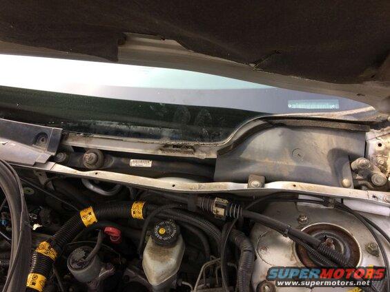 Remove the wipers, cowel cover and weather strip. I have the two piece cowel, and was able to remove the one cowel clip and lift the cowel to access the one bolt.