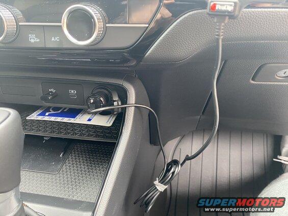 Car center console with USB port, 12V charger, and wireless charging pad.