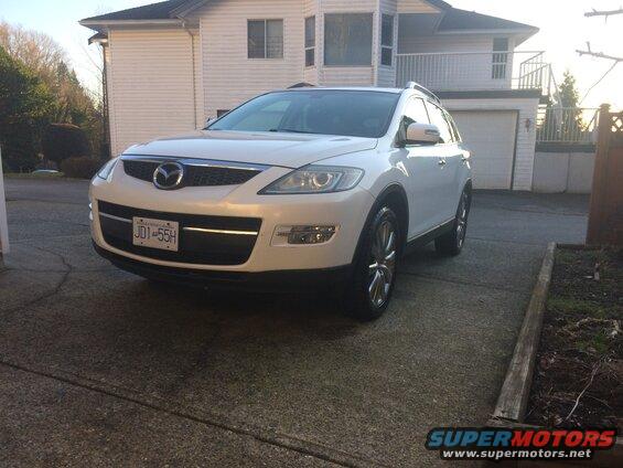 White 2009 Mazda CX-9 SUV parked in driveway, front view.