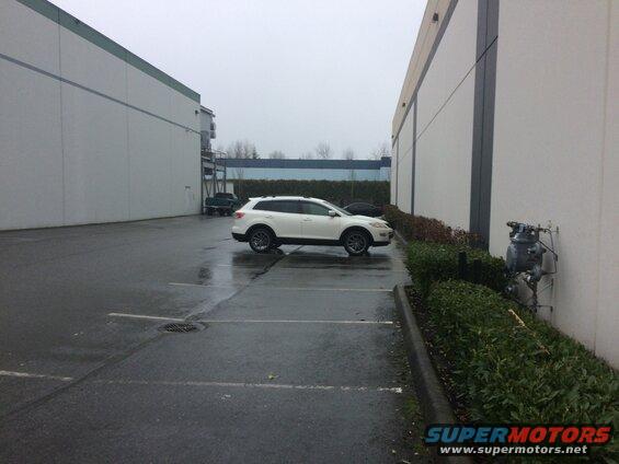 White 2009 Mazda CX-9 parked in a lot next to a building.