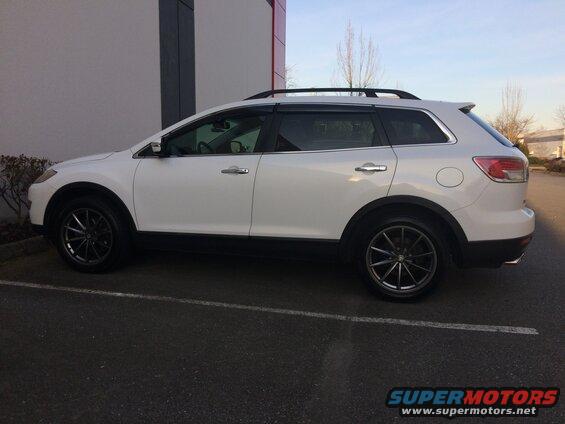 White 2009 Mazda CX-9 SUV parked in a lot, side view, showing aftermarket wheels.