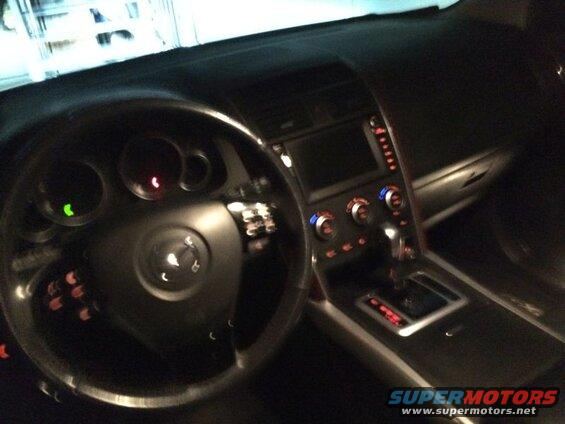 Interior view of a 2009 Mazda CX-9 dashboard, steering wheel, and center console.