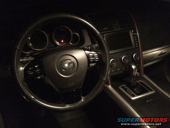 Interior of a Mazda CX-9 showing the steering wheel, dashboard, and center console.