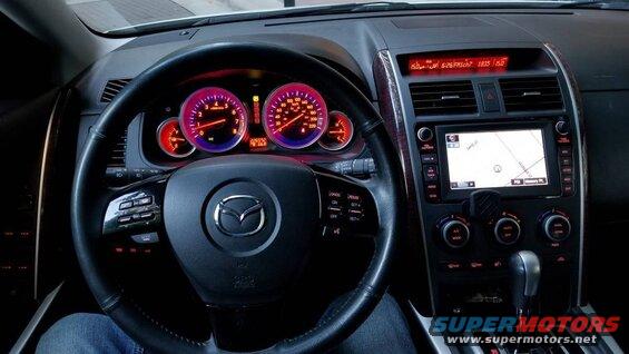 Interior view of a Mazda CX-9 dashboard with illuminated gauges and navigation screen.