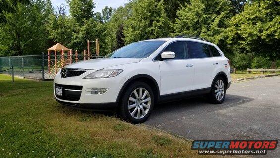 White 2009 Mazda CX-9 parked at a park with a playground.