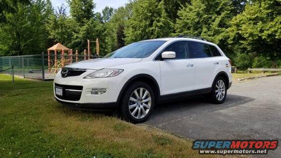 White 2009 Mazda CX-9 parked next to a playground.