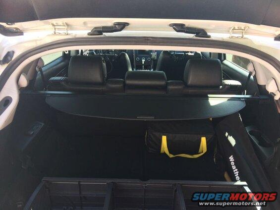 Interior rear cargo area of a white SUV with storage bags.