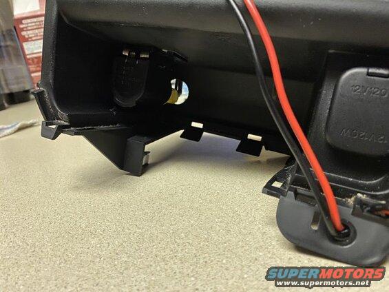 Close-up of 12V power outlet and cigarette lighter socket in a black vehicle interior.
