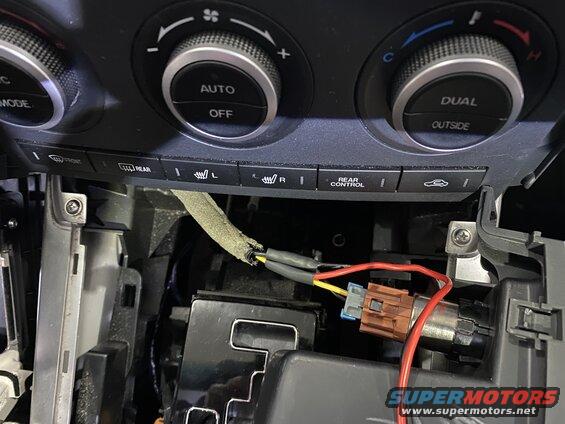 Car center console with climate controls, wiring, and connector.