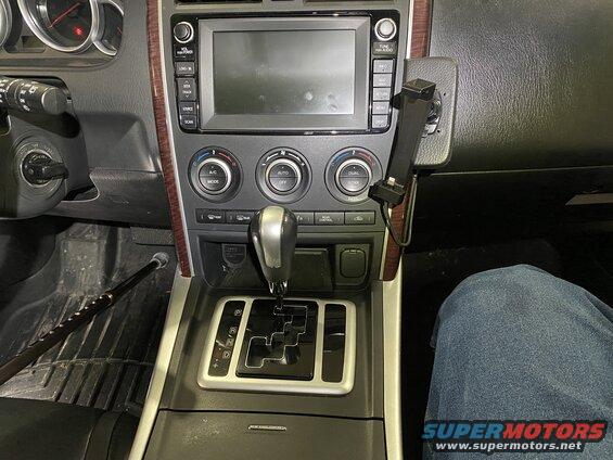 Interior of a 2009 Mazda CX-9 center console with gear shifter, climate controls, infotainment screen, and phone mount.